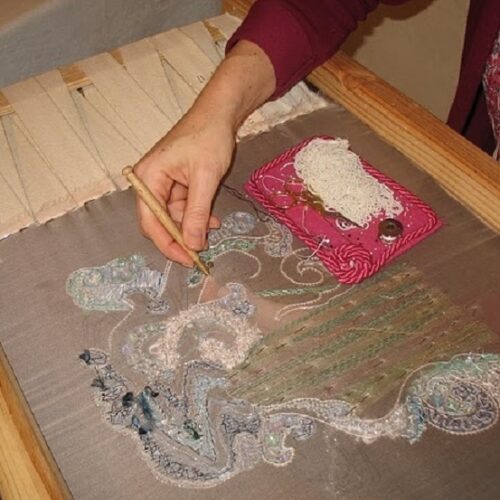 Brodeuse au crochet de Lunéville, brodant sur métier à broder.